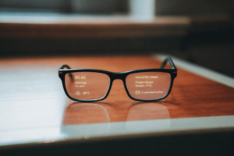Brille auf einem Tisch mit KI Text auf den Gläsern